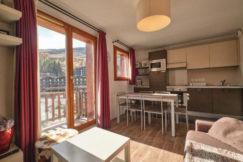 eine Küche und ein Wohnzimmer mit einem großen Fenster in der Unterkunft Coeur d'ours in Les Deux Alpes