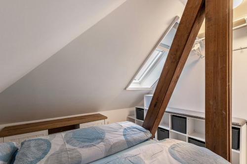 a small attic bedroom with a bed and a window at Ferienwohnung Backbord Deichhausen in Büsumer Deichhausen