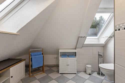 a attic bathroom with a toilet and a window at Ferienwohnung Backbord Deichhausen in Büsumer Deichhausen