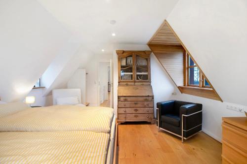 ein Dachgeschoss-Schlafzimmer mit zwei Betten und einem Stuhl in der Unterkunft Olendeel in Gelting