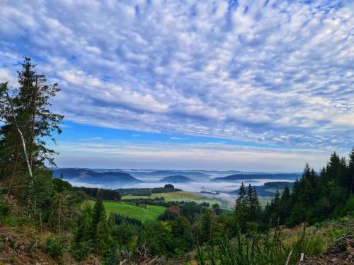 a view of a valley in the hills with clouds at Ferienwohnungen Dorfliebe Dörnberg in Bestwig