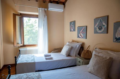a bedroom with two beds and a window at Tuscan Retreat Private Spa Villa in Lucignano