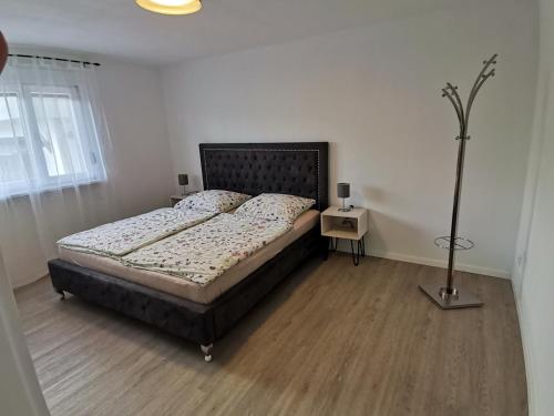 a bedroom with a bed and a lamp on a wooden floor at Ferienwohnung bei Bojko in Oberkirch