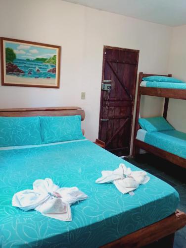 a bedroom with a bed with towels on it at Pousada Quintal da Cachoeira in São Thomé das Letras