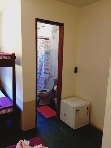 a bathroom with a toilet in a room at Pousada Quintal da Cachoeira in São Thomé das Letras