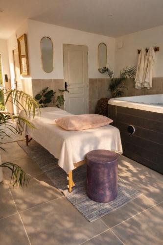 a room with a bed and a tub and a table at Un Chalet au Verger-Dog friendly-Jacuzzi & Massages in Conteville