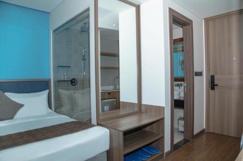 a bedroom with a bed and a shower and a mirror at Apec Beach Luxury Phú Yên in Tuy Hoa