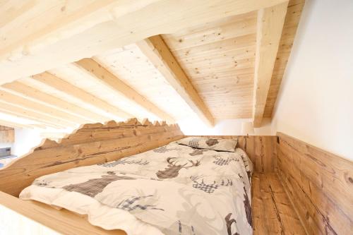 a bed in a room with a wooden ceiling at Bellagio - Baita treeb Breva in Bellagio