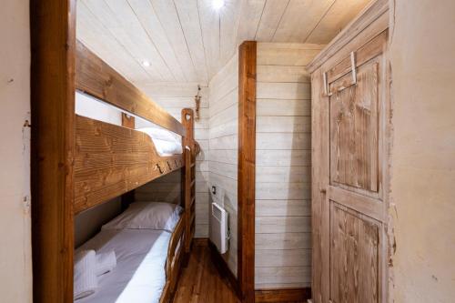 a bedroom with two bunk beds and a door at Appartement Roméo in Champagny-en-Vanoise