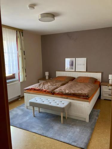 a bedroom with a large bed with a bench in it at Ferienwohnungen am Louisenteich in Frauendorf