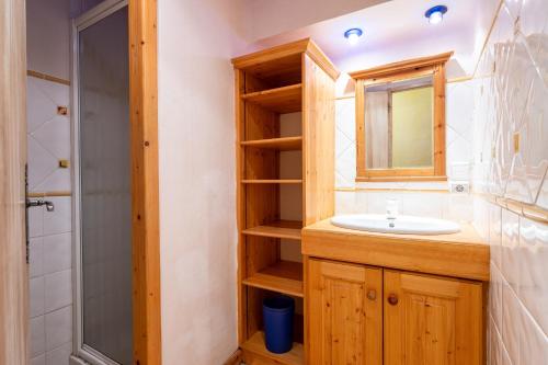 a bathroom with a sink and a mirror and a shower at Appartement Roméo in Champagny-en-Vanoise