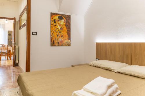 a bedroom with two beds and a painting on the wall at Vito 80 in Chiaramonte Gulfi