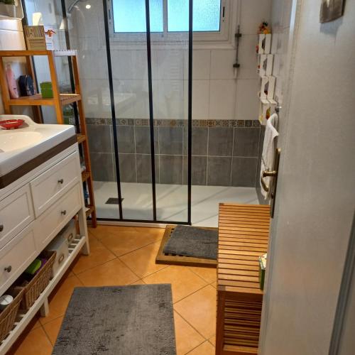 a bathroom with a shower with a glass door at Ty Clafout wifi parking in Saint-Nolff