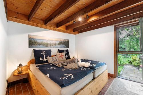 a bedroom with a bed in a room with wooden ceilings at Ferienhaus Karlsminde in Waabs