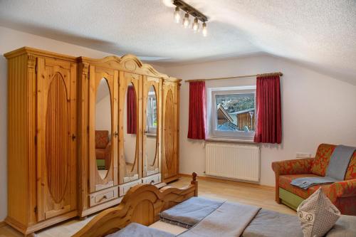 a living room with a wooden cabinet and a couch at Hof Almfrieden - Dormitz in Nassereith