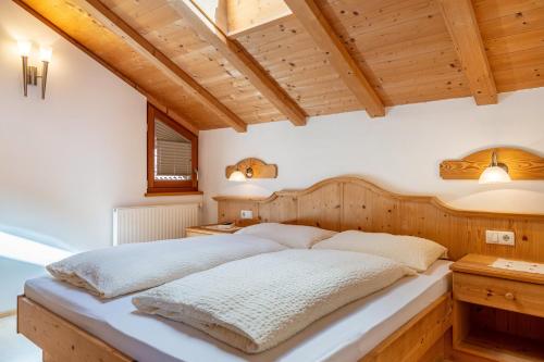 a bedroom with a large bed in a room with wooden ceilings at Haus Alpenblick Apt Brunelle in Laion