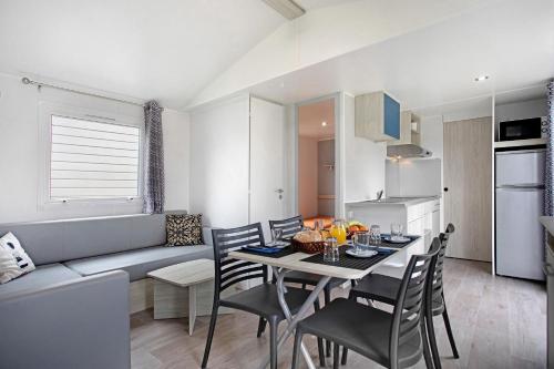 a kitchen and a dining room with a table and chairs at Bungalow T2 I I- 15 Min From Nazaré in Pataias