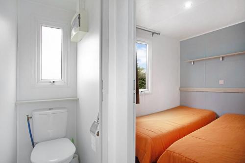 a small bedroom with a bed and a toilet at Bungalow T2 I I- 15 Min From Nazaré in Pataias