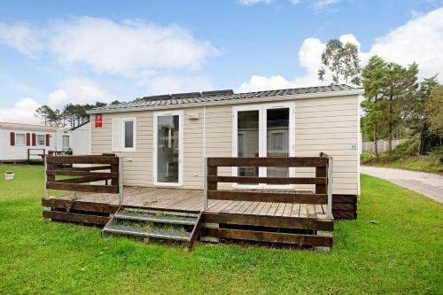 a tiny house with a porch and a deck at Bungalow T2 I I- 15 Min From Nazaré in Pataias