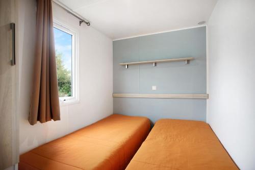 a bedroom with an orange bed and a window at Bungalow T2 I I- 15 Min From Nazaré in Pataias