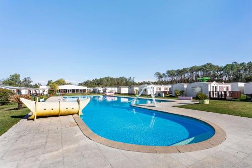 a large swimming pool with a slide in a yard at Bungalow T2 I I- 15 Min From Nazaré in Pataias