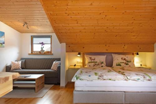 a bedroom with a bed and a couch at Ferienwohnung Wendelinus in Rettenberg