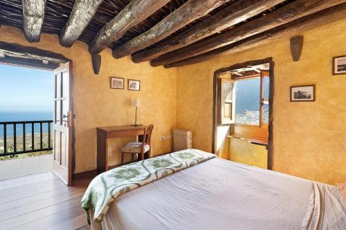 a bedroom with a bed and a large window at El Lagar in Frontera