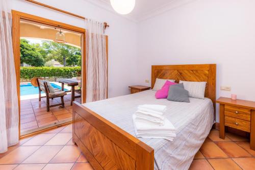 a bedroom with a bed and a balcony with a table at Ca Na Rosa in Alcudia