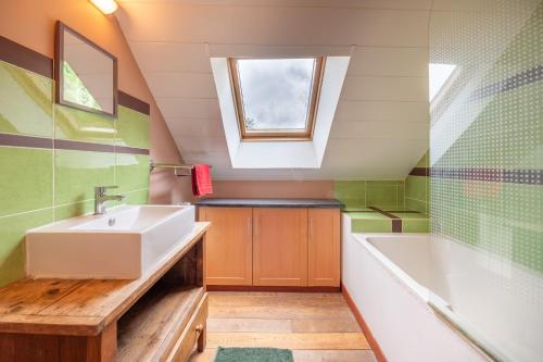 a bathroom with a sink and a tub and a window at Ville Moizo in Sérent