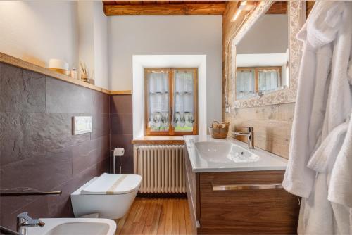 a bathroom with a sink and a toilet and a mirror at Nini's Home in Schignano