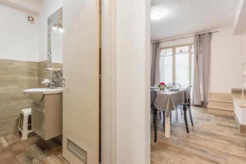 a kitchen and dining room with a table and a sink at Casavacanzefranca - 12 in Terrasini