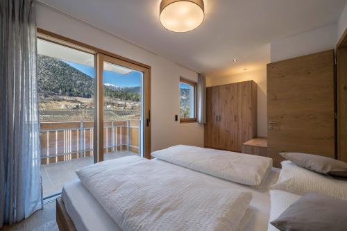 a bedroom with two beds and a large window at sunnig Apartment Sonnenlicht in Vollan
