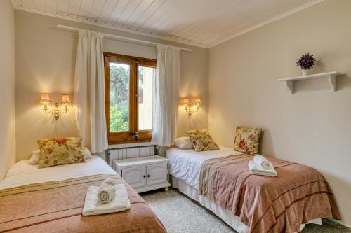a bedroom with two beds and a window at Casa adosada in Begur