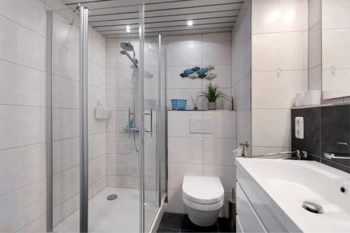 a bathroom with a shower and a toilet and a sink at Ostseeperle mit Schwimmbad in Dahme