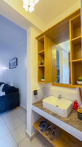 a bathroom with a sink and a blue couch at Diani Hideouts 2 in Kwale