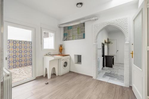 a white bathroom with a washing machine in a room at Little Alhambra in Dúrcal