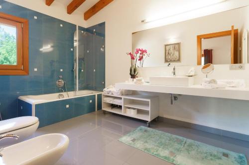 a bathroom with two sinks and a tub and a toilet at Villa Golf Marina Premium in Pollença