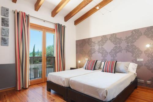 a bedroom with a large bed and a balcony at Villa Golf Marina Premium in Pollença