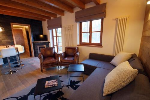 a living room with a couch and chairs and a fireplace at Villaggio delle Alpi in Pré-Saint-Didier