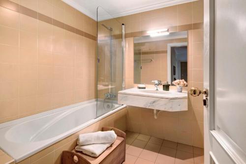 a bathroom with a tub and a sink and a shower at Seaside Escape in Funchal
