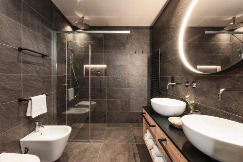 a bathroom with two sinks and a shower at Oberplunerhof Luxury Chalet Skyline in Chienes
