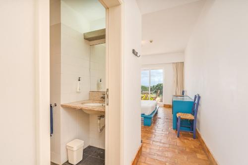 a bathroom with a tub and a sink in a room at Alto da Lua in Bordeira