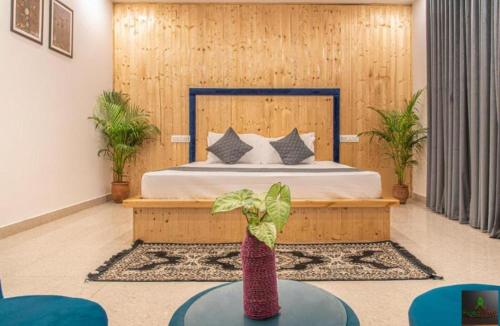 a bedroom with a bed and a table with a plant at Himalayan Mist Retreat By Cloud Berry stays kasauli in Dharampur