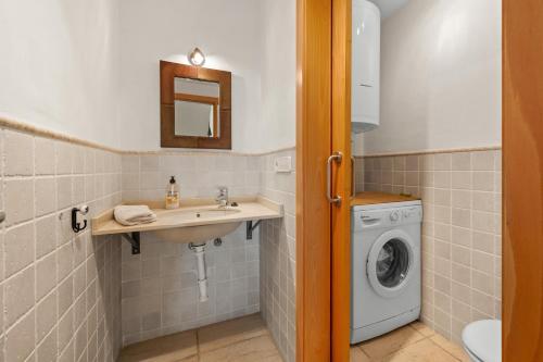 a bathroom with a sink and a washing machine at Villa Fuentes in Almuñécar