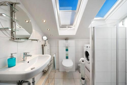 a bathroom with a sink and a toilet and a skylight at Ferienwohnung Panoramablick in Lenzkirch
