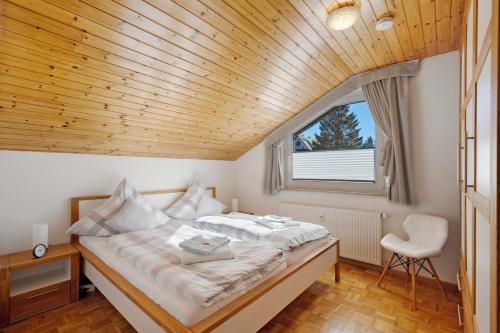a bedroom with a bed with a wooden ceiling at Ferienwohnung Panoramablick in Lenzkirch