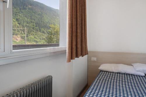 a bed in a room with a window at Marilleva 900 Kristall in Mezzana