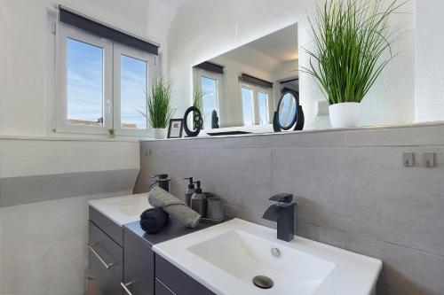 a bathroom with a sink and two mirrors at Fewo Zeitzauber in Marsberg