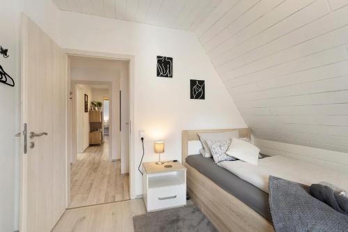 a small bedroom with a bed and a hallway at Fewo Zeitzauber in Marsberg