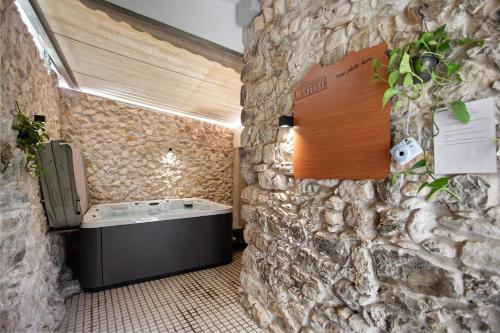 a bathroom with a stone wall with a bath tub at Residencia Dos Castelos in Santarém
